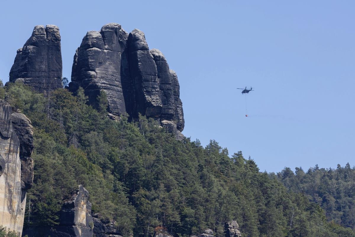 Ein Löschhubschrauber der Bundeswehr ist bei den Waldbränden in der Sächsischen Schweiz im Einsatz. Die Situation im Waldbrandgebiet Nationalpark Sächsische Schweiz ist noch nicht unter Kontrolle. Der Waldbrand im Nationalpark hat den Aufschwung der Tourismuswirtschaft nach der Corona-Pandemie gestoppt.