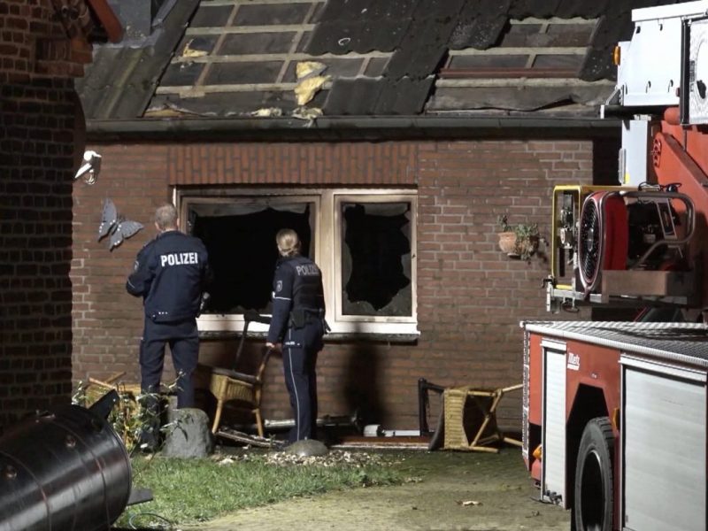 NRW, Hamminkeln: Zwei Polizisten inspizieren den Brandort.