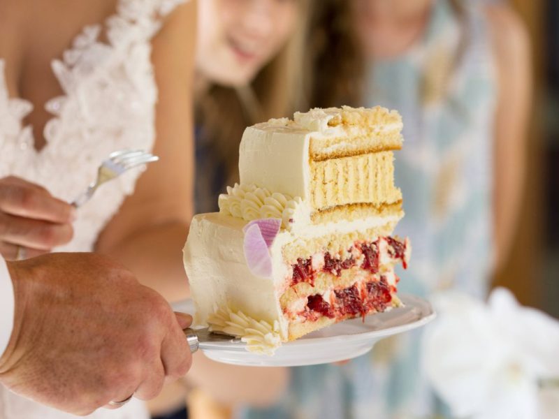 Hochzeit Braut und Bräutigam schneiden Torte an