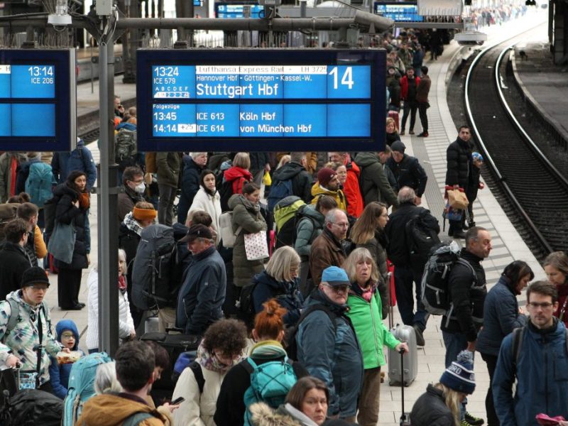 Deutsche Bahn Reisende warten am Gleis