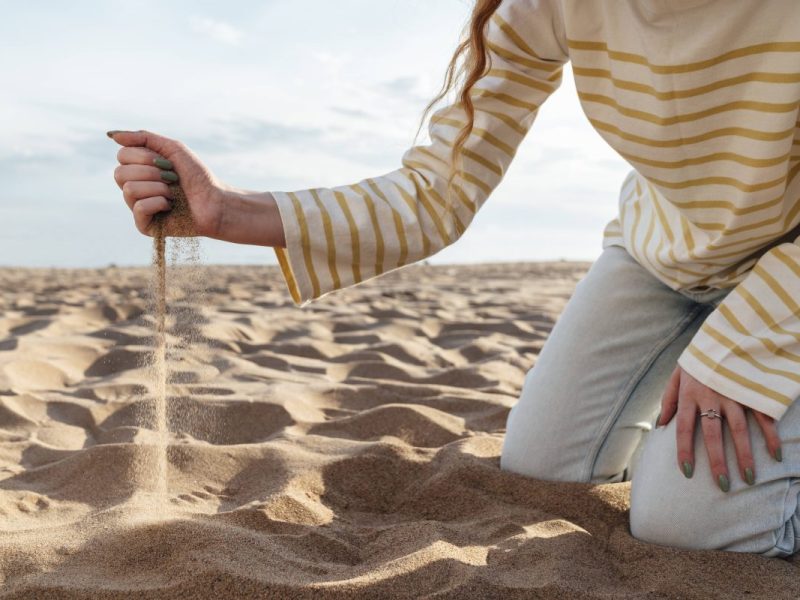 Urlaub an der Ostsee Frau gräbt im Sand