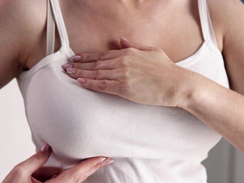 Frau tastet Brust ab