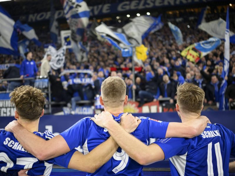 Cedric Brunner (l.) schaut auf die Fankurve des FC Schalke 04.