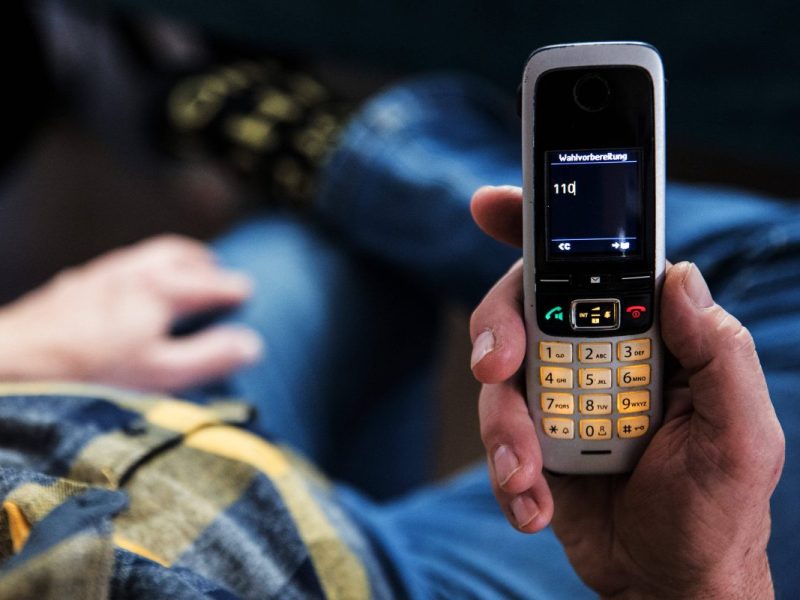 Senior mit Haustelefon und 110 im Display