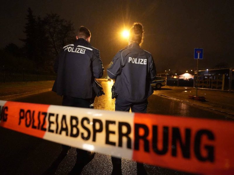Polzeiabsperrband und Polizisten auf Straße