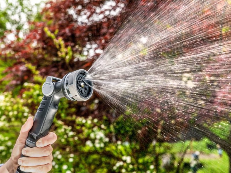 Wasserschlauch mit Düse zum Rasenbewässern