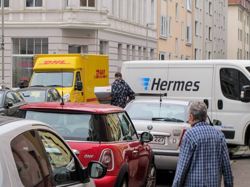DHL- und Hermes-Paketwagen im Straßenverkehr
