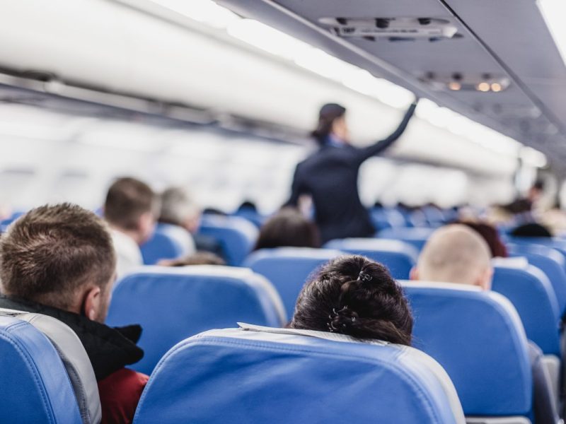 Passagiere und Stewardess im Flugzeug