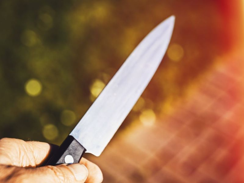 Männerhand mit Messer.