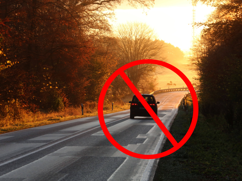 Ein Auto fährt auf einer Landstraße.