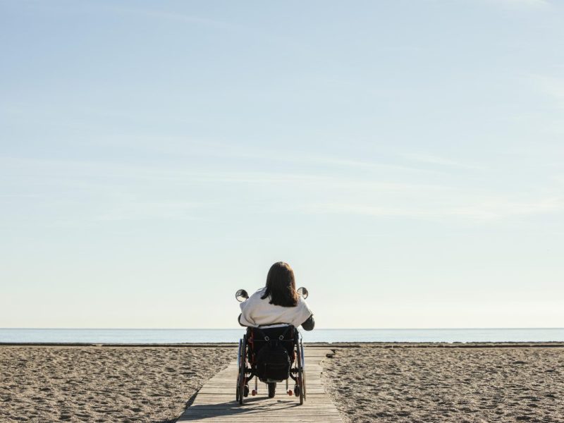 Frau im Rollstuhl am Strand