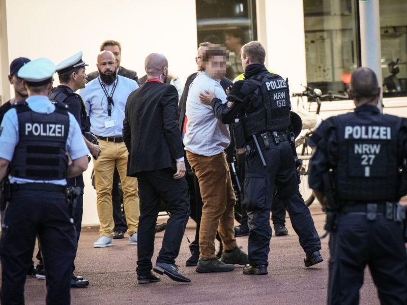AfD in Essen: Ein Demonstrant wird aus der Philharmonie geführt.