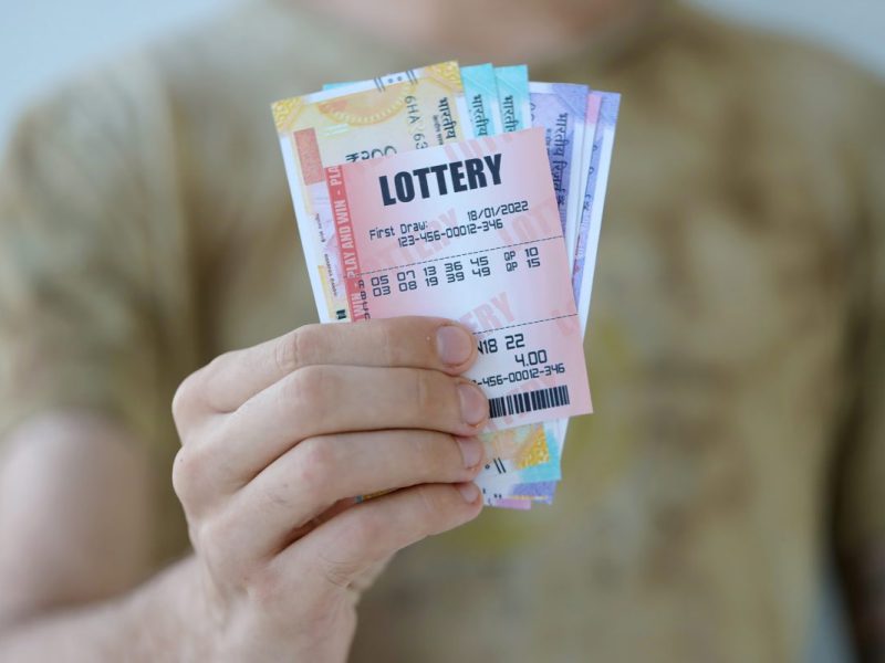 Mann hält Lotto-Spielschein in der Hand