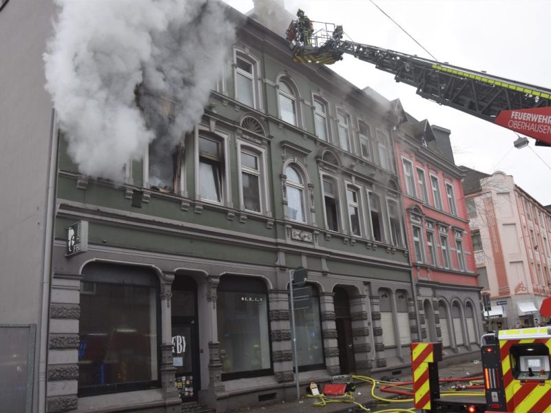 Dichter Rauch quillt aus der brennenden Wohnung in Oberhausen. Per Drehleiter rettet die Feuerwehr eingeschlossene Bewohner aus den anderen Wohnungen.
